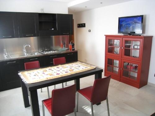 平佐洛Sillia Appartamenti的厨房配有桌椅和电视。
