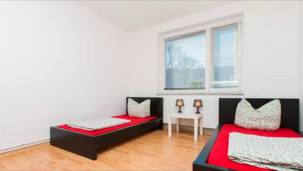 汉诺威City Apartment 6 Personen的客房设有两张床、一张桌子和一扇窗户。