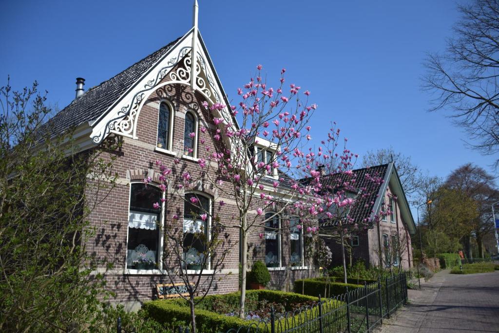 TwiskHet Twiscker Huys的砖房,上面有粉红色的花