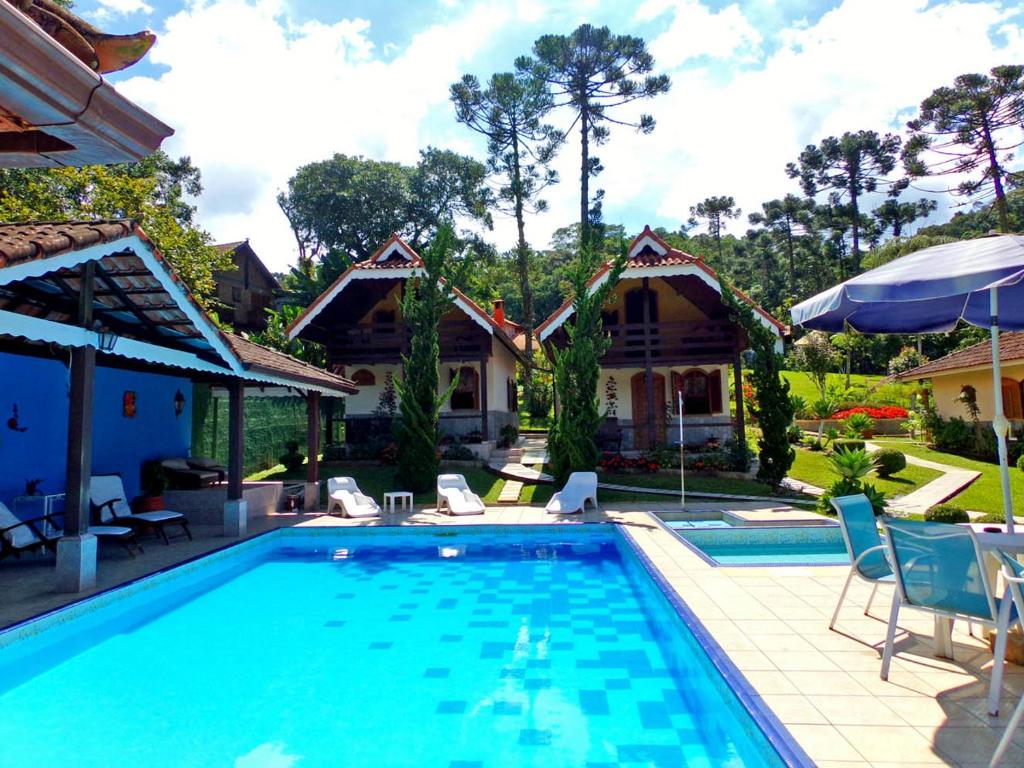 维奥康德马奥Hotel Cantinho de Férias的一个带椅子的游泳池以及一座房子