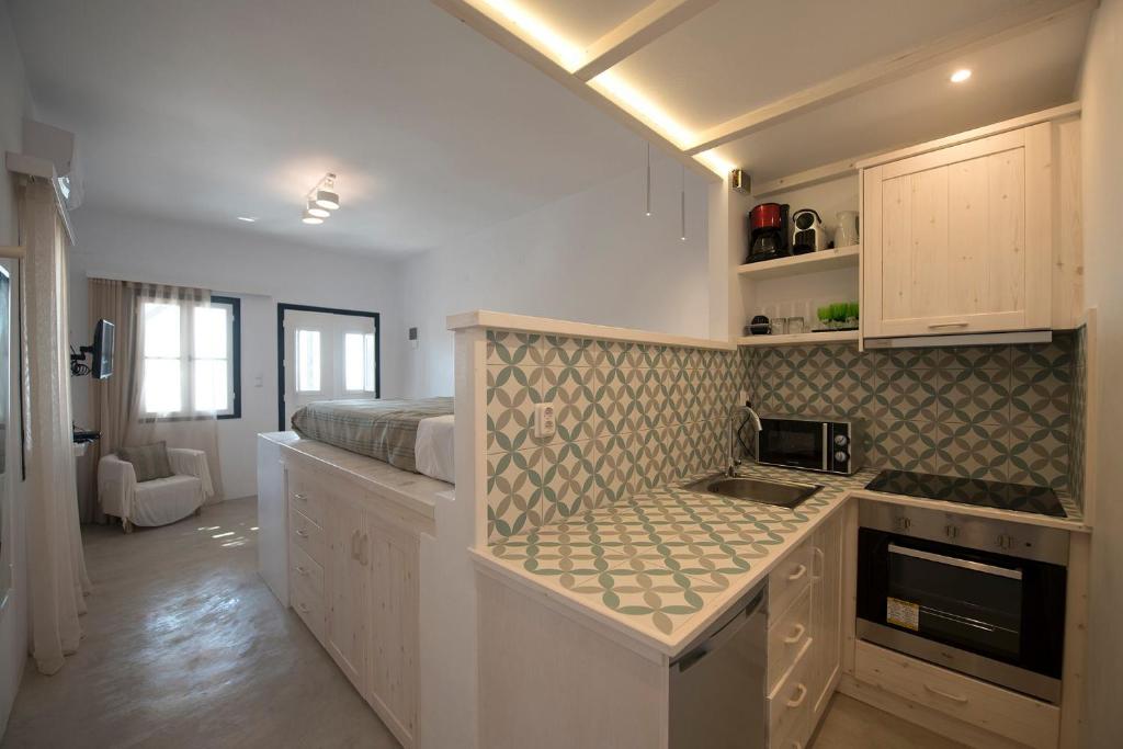 卡利诺岛Blue Dawn Kalymnos的一个带水槽的厨房和一张位于客房内的床