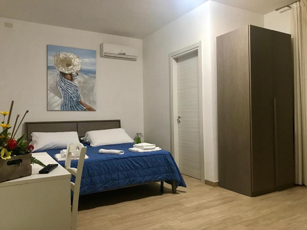 托里德欧索Baia Dell'Orso的一间卧室配有一张床、一张桌子和一幅画