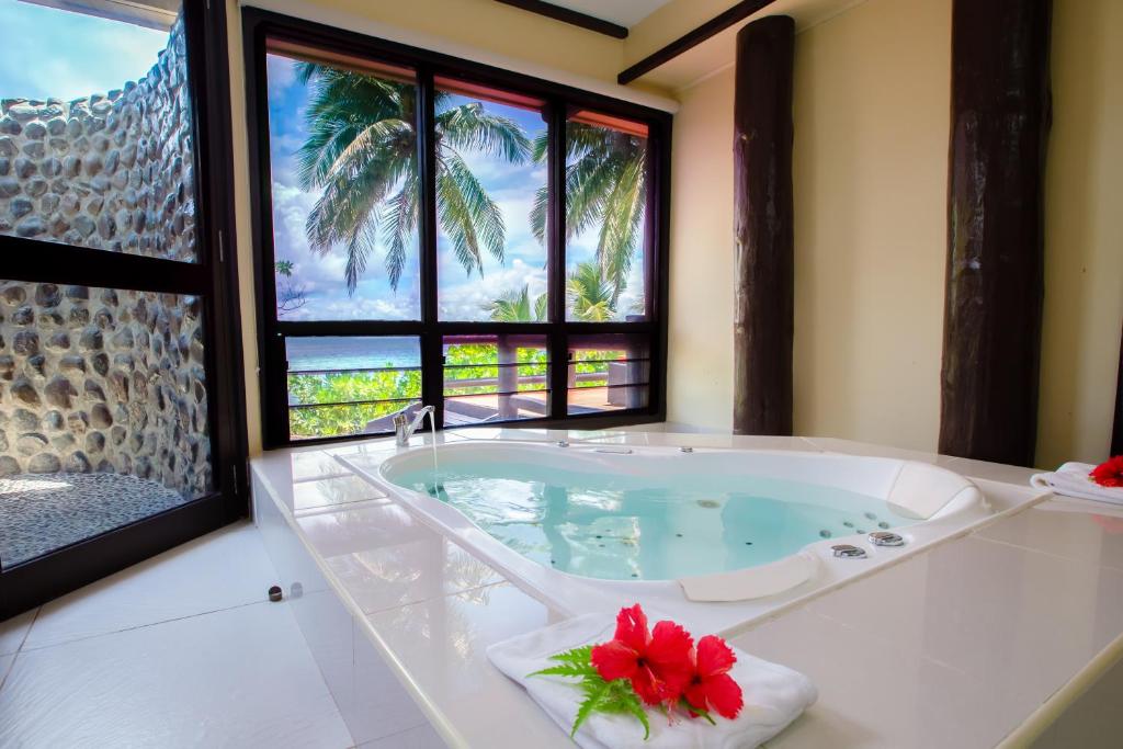 玛娜岛玛那岛Spa度假酒店-斐济的一间带浴缸的浴室,享有棕榈树的景色