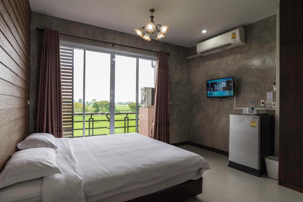 坤西育府纳瓦度假酒店的卧室配有床、冰箱和窗户。