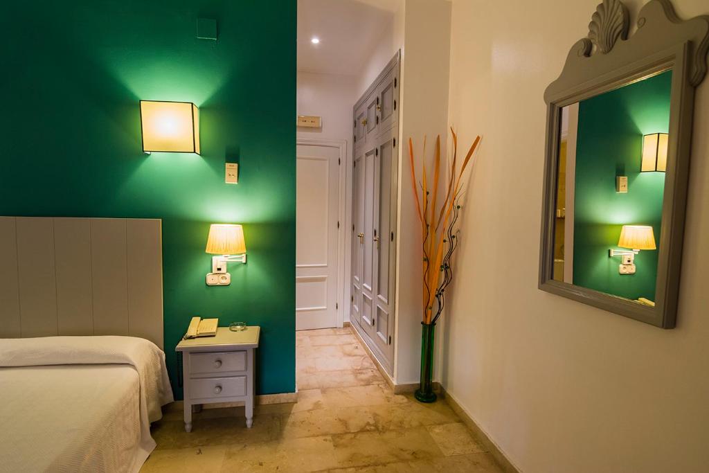 普韦布洛·纽沃·德·加德德拉戈旅馆的一间卧室设有绿色的墙壁、一张床和镜子