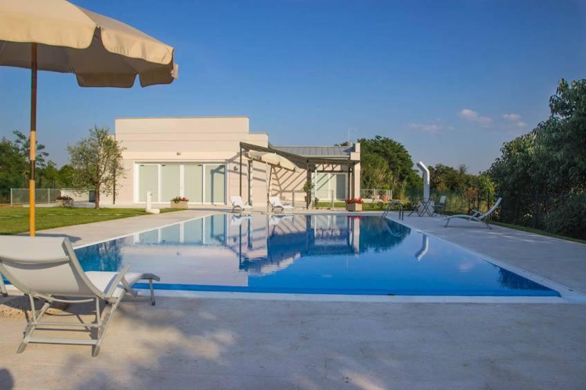 维罗纳Agriturismo Dell'Orto Apartments的一个带椅子和遮阳伞的游泳池