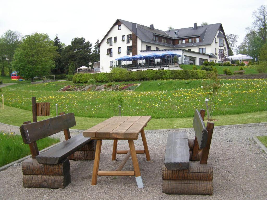 Lengefeld瓦尔德斯鲁酒店的木屋前的木餐桌和长凳