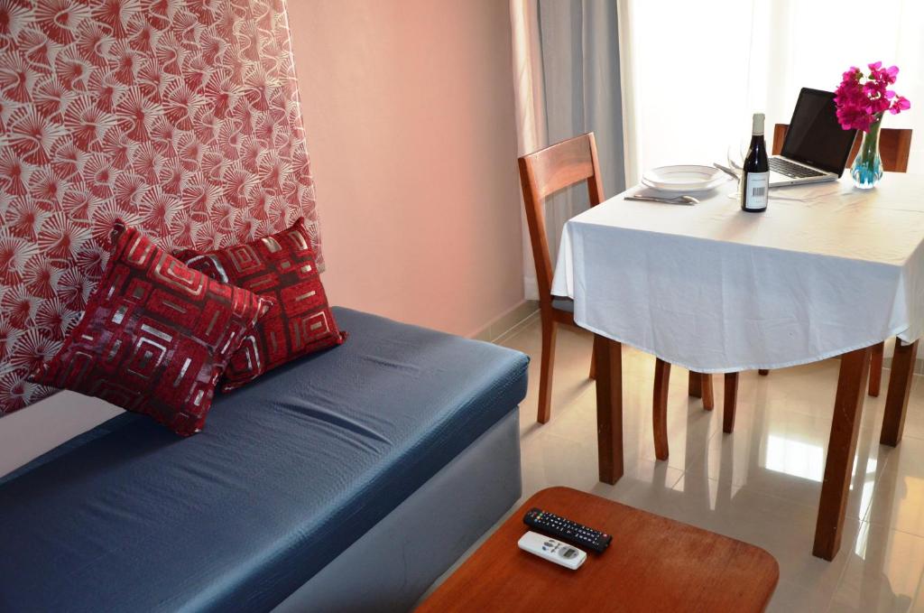 阿比让Résidence Bertille Abidjan Cocody的客厅配有蓝色的沙发和桌子