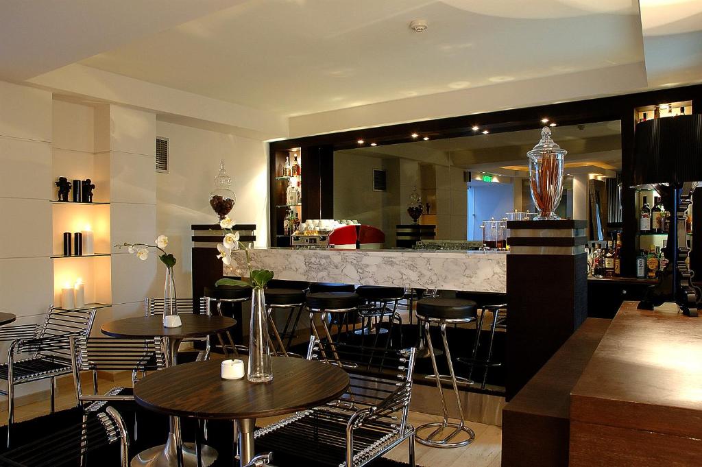 卡斯托里亚安德洛墨达精品酒店的餐厅内的酒吧配有桌椅