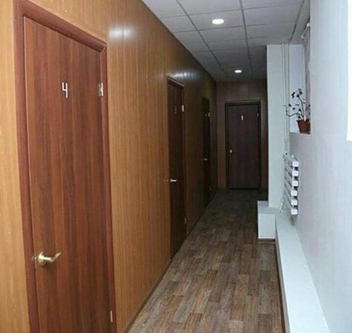巴甫洛达尔мини-отель "Алатау"的空的走廊,设有木门和木地板