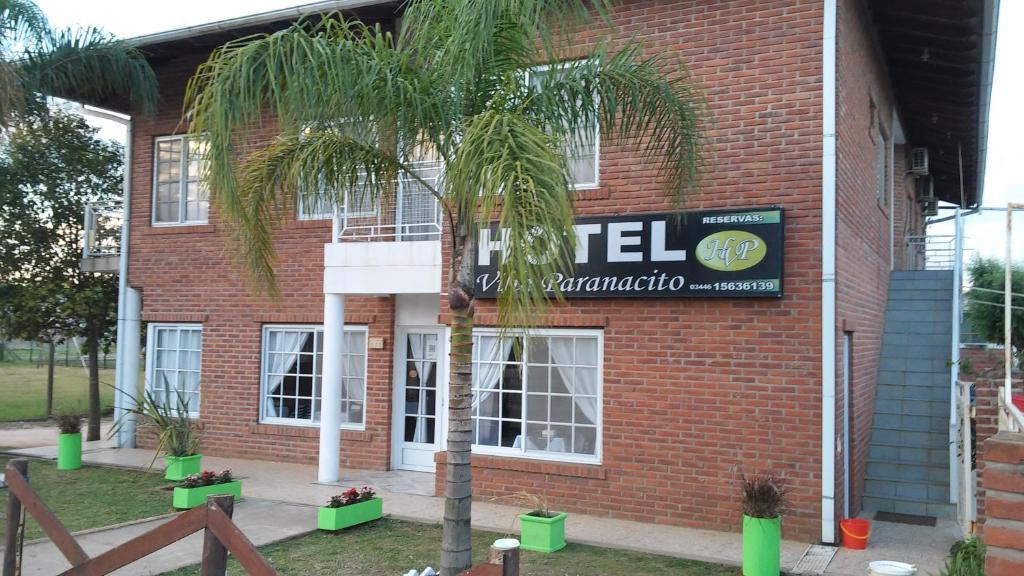 帕拉纳西托镇Hotel Villa Paranacito的砖楼前的棕榈树