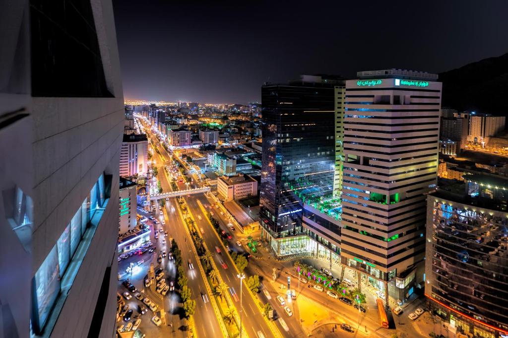 麦加Holiday Suites Al Azizia的夜间有交通的城市