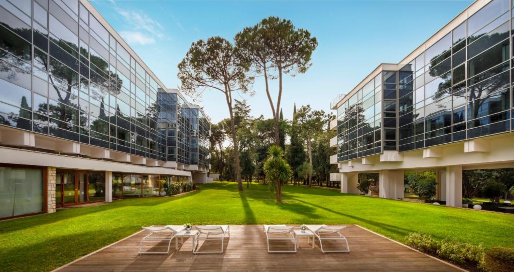 罗维尼Eden Hotel by Maistra Collection的享有带草坪和椅子的建筑的外部景色