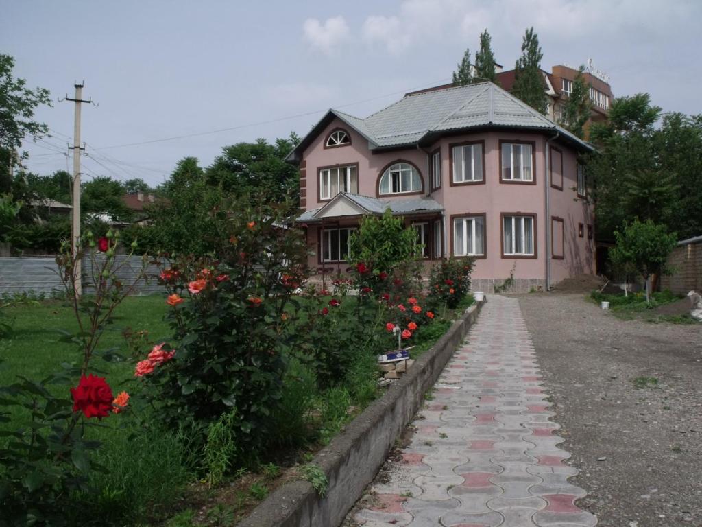 奥什Hostel Visit Osh的粉红色的房子,前面有走道