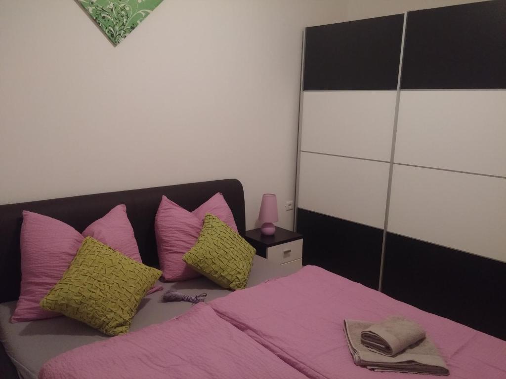 克罗诺维察Hostel **Casa del Sole**的一间卧室配有带粉色和黄色枕头的床