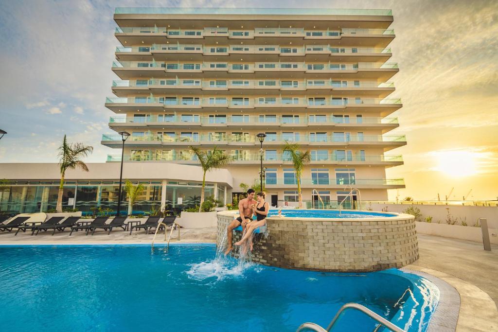 阿里卡Antay Hotel & Spa的两人坐在酒店游泳池里