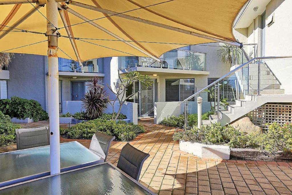 珀斯Beachfront @ Scarbs的一个带遮阳伞和游泳池的庭院