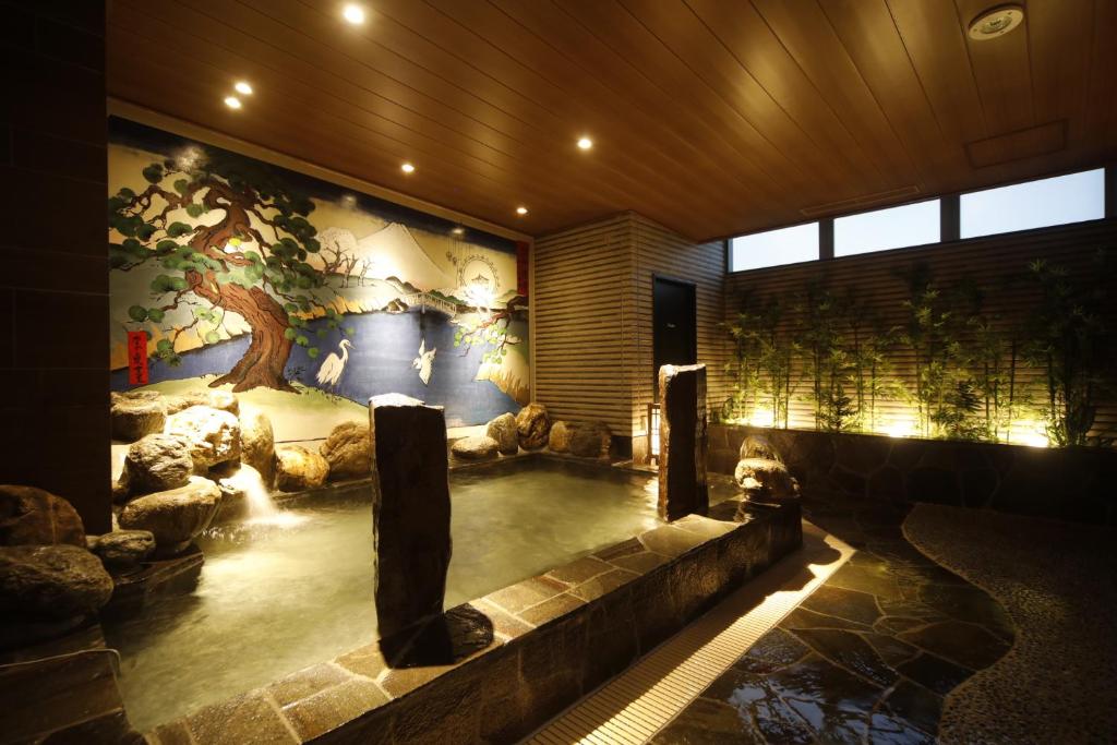 东京多美迎后乐园酒店的一座有树壁画的房子里的室内游泳池