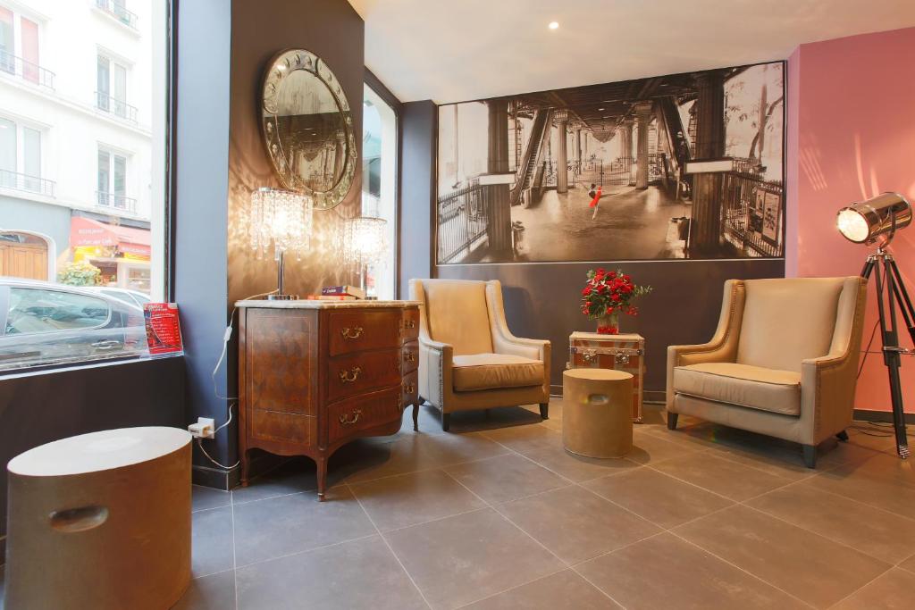 巴黎阿特利尔瓦万酒店的一个带两把椅子、一张桌子和一面镜子的沙龙