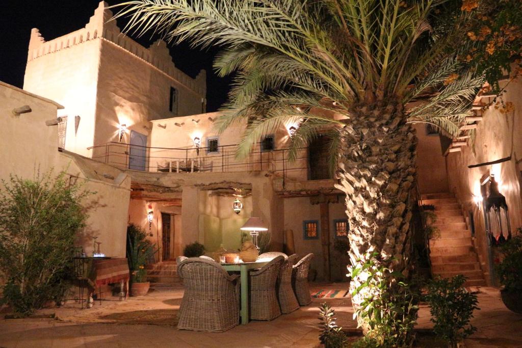 塔鲁丹特凯瑟特奥酒店的一座带桌子的建筑前的棕榈树