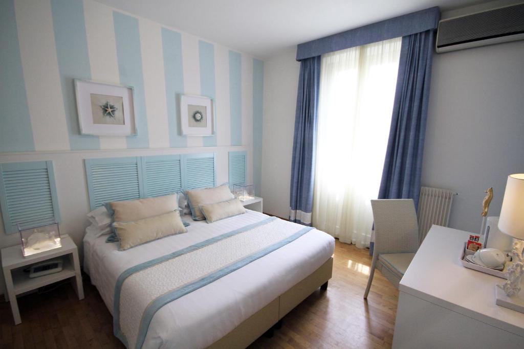 马尔米堡Raffaelli Villino Limoni的一间卧室配有一张蓝色和白色条纹的床