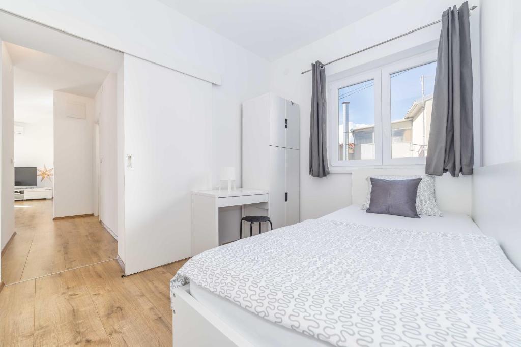 沃迪切Apartments Tonka Centar的白色的卧室设有一张大床和一个窗户