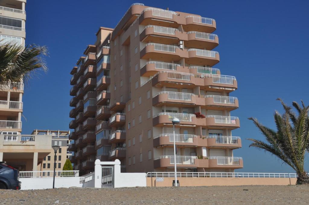 奥罗佩萨德尔马Galicia Vidaber Primera Línea的海滩上高大的公寓楼,有棕榈树
