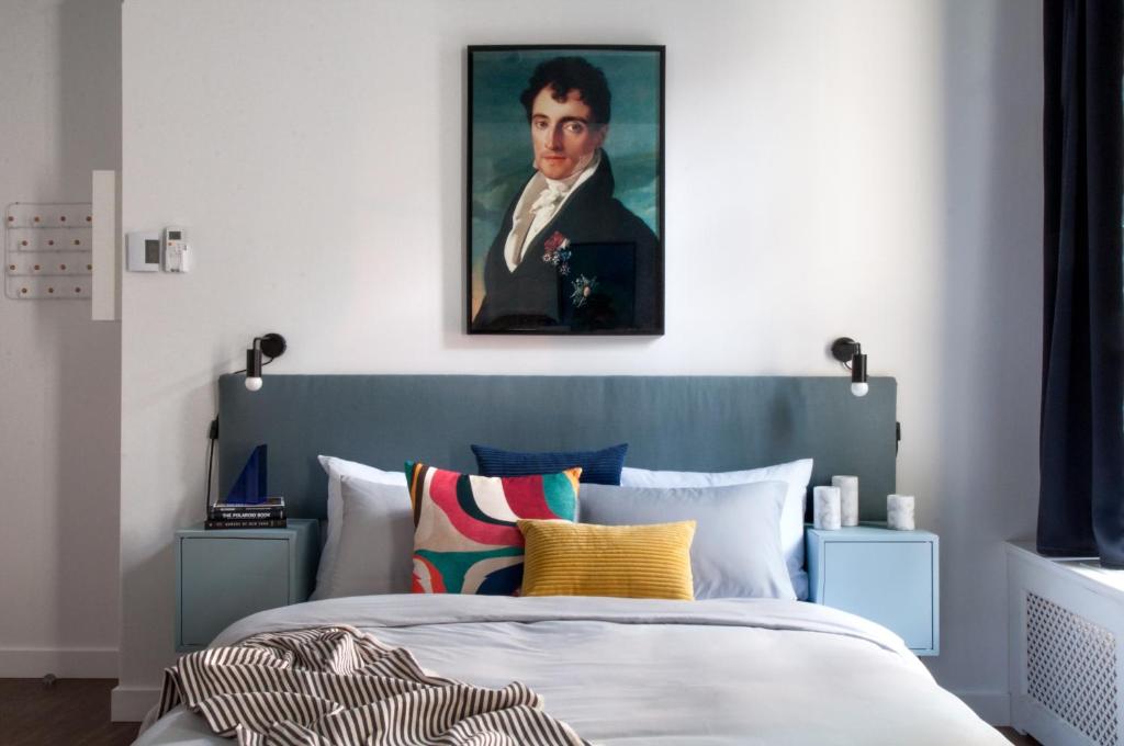 蒙特利尔Maison Saint-Vincent By Maisons & co的卧室配有一张带人画的床