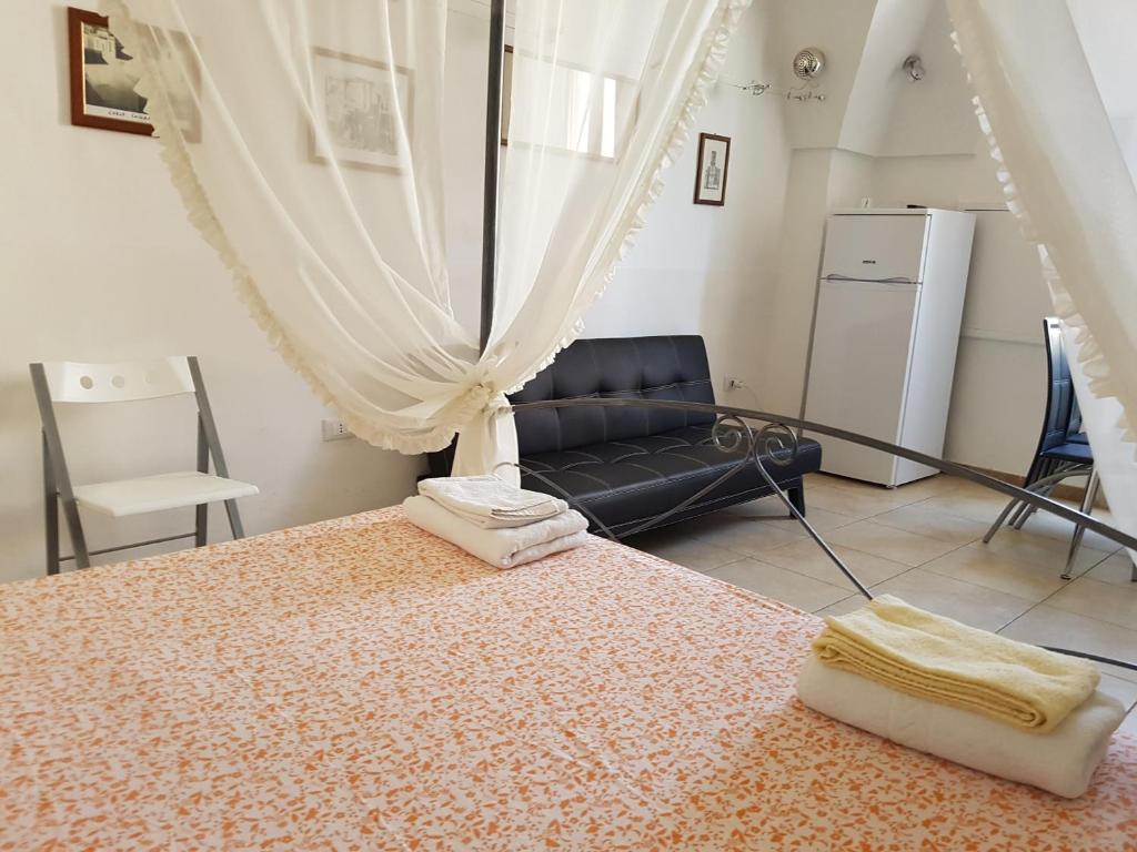 科里利亚诺多特兰托Calì Nitta Storic的一间卧室配有一张床和一个沙发