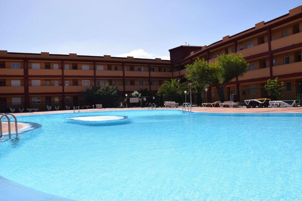 拉奥利瓦Caleta Relax - Apartamento Fuerteventura Apartment的大楼前的大型游泳池