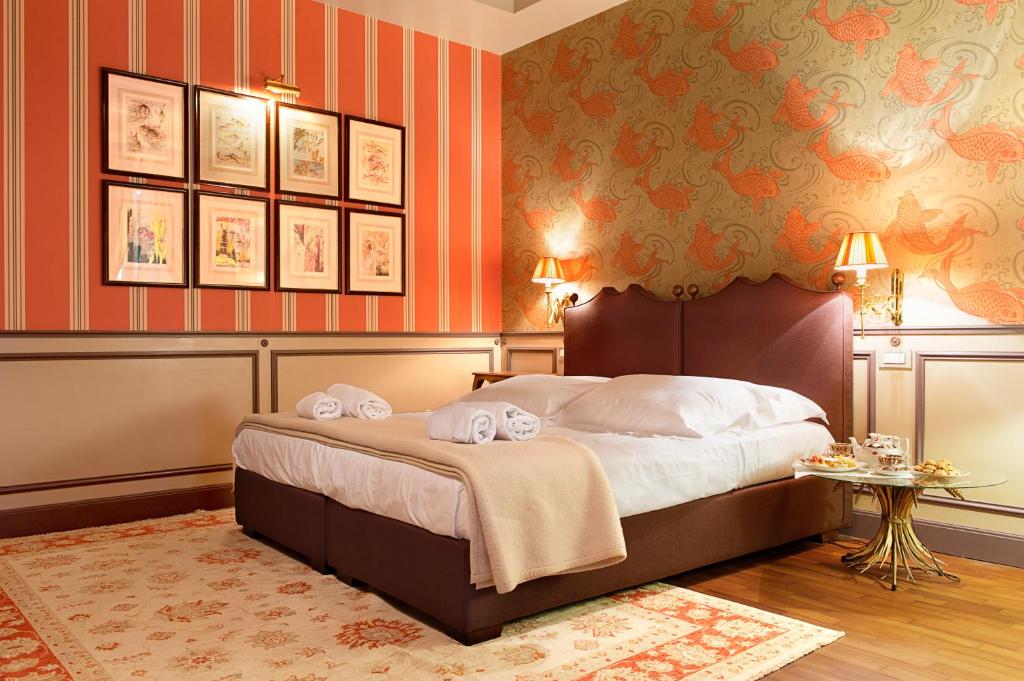 维罗纳波尔莎里住宅酒店的一间卧室配有一张带橙色墙壁的大床