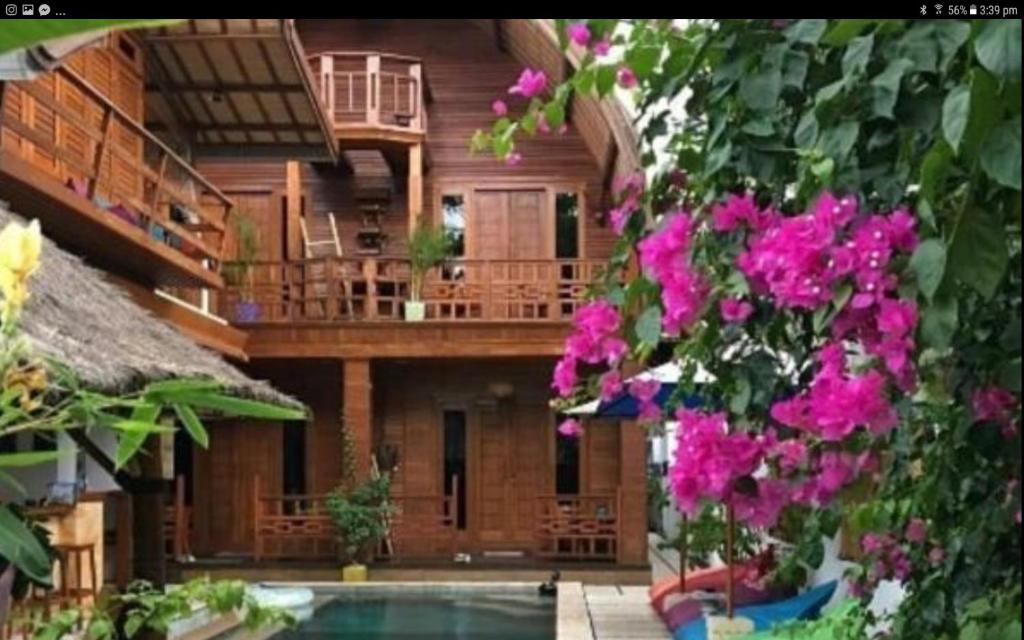 吉利特拉旺安吉利糖小屋旅馆的一座带游泳池和一些粉红色鲜花的房子