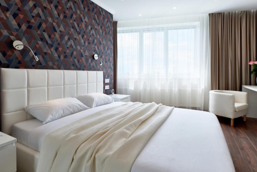基辅Apartment near Lukyanovka Square的卧室设有一张白色大床和一扇窗户。