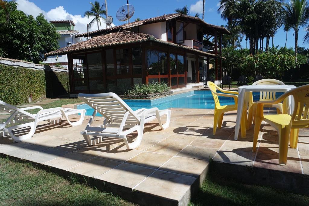 塞古罗港Residencial Frente a Praia的一组椅子和桌子,位于游泳池旁
