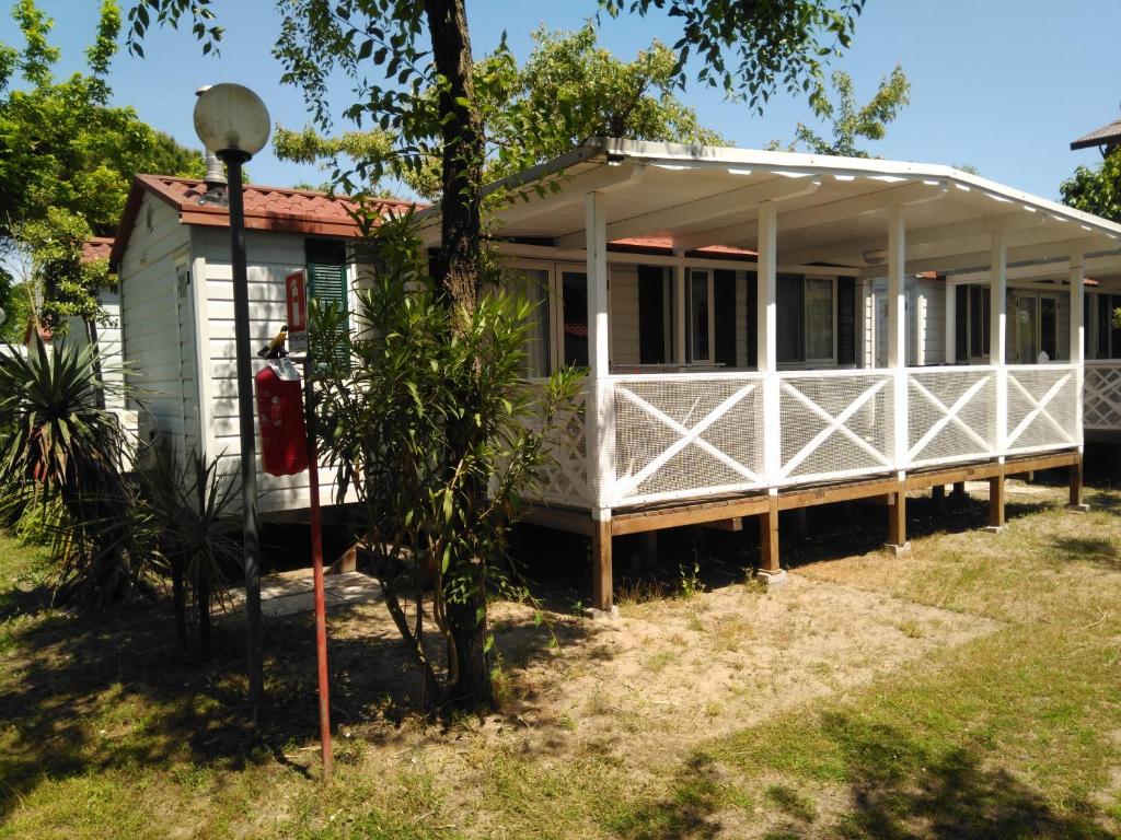 卡瓦利诺AdriaCamp Mobile Homes Cavallino的前面有一个红色邮箱的白色房子