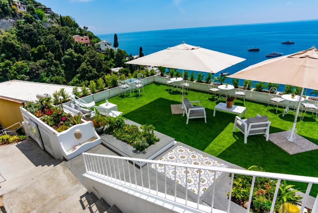 波西塔诺桑塔彼得拉别墅的一个带桌子和遮阳伞的户外露台,享有海景。