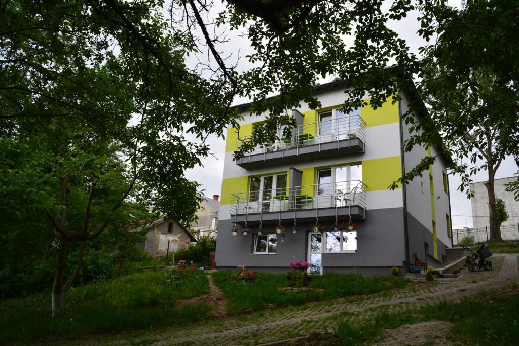 特鲁斯卡韦茨Guest House at Lesya Ukrainka的黄色和白色的建筑,设有阳台