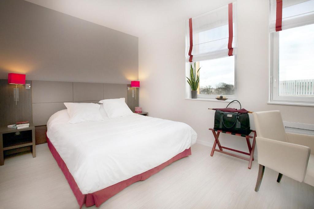 兰斯里塞德宏兰斯中心公寓的卧室设有一张白色大床和两个窗户。
