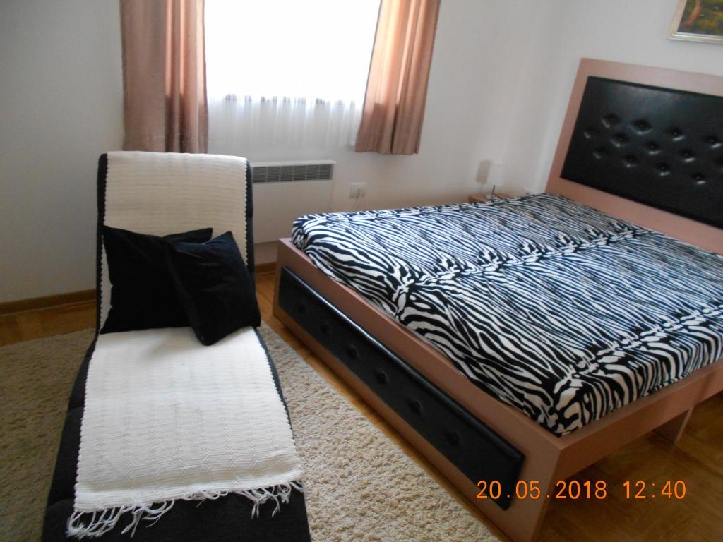 兹拉蒂博尔Apartment Katrin的一间卧室配有一张床和一把椅子