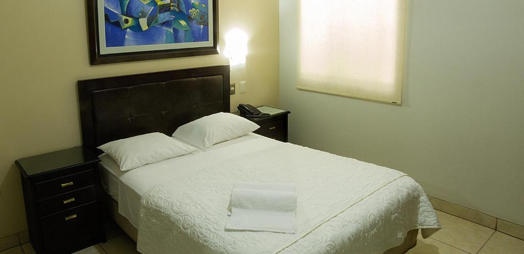 皮乌拉Rivera del Rio Hotel的一间卧室配有一张带白色毯子的大床