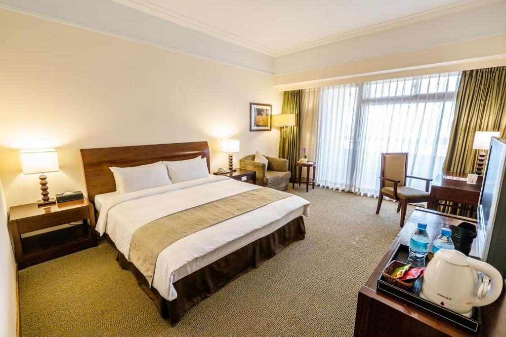 中坜福容大饭店 - 中坜的酒店客房设有一张大床和一张书桌。