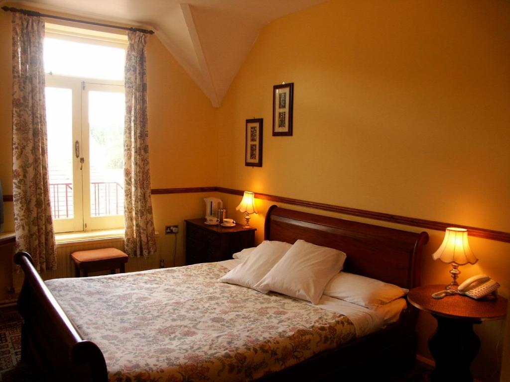福里斯特罗契克斯旅馆酒店的一间卧室配有一张带两盏灯的床和一扇窗户。