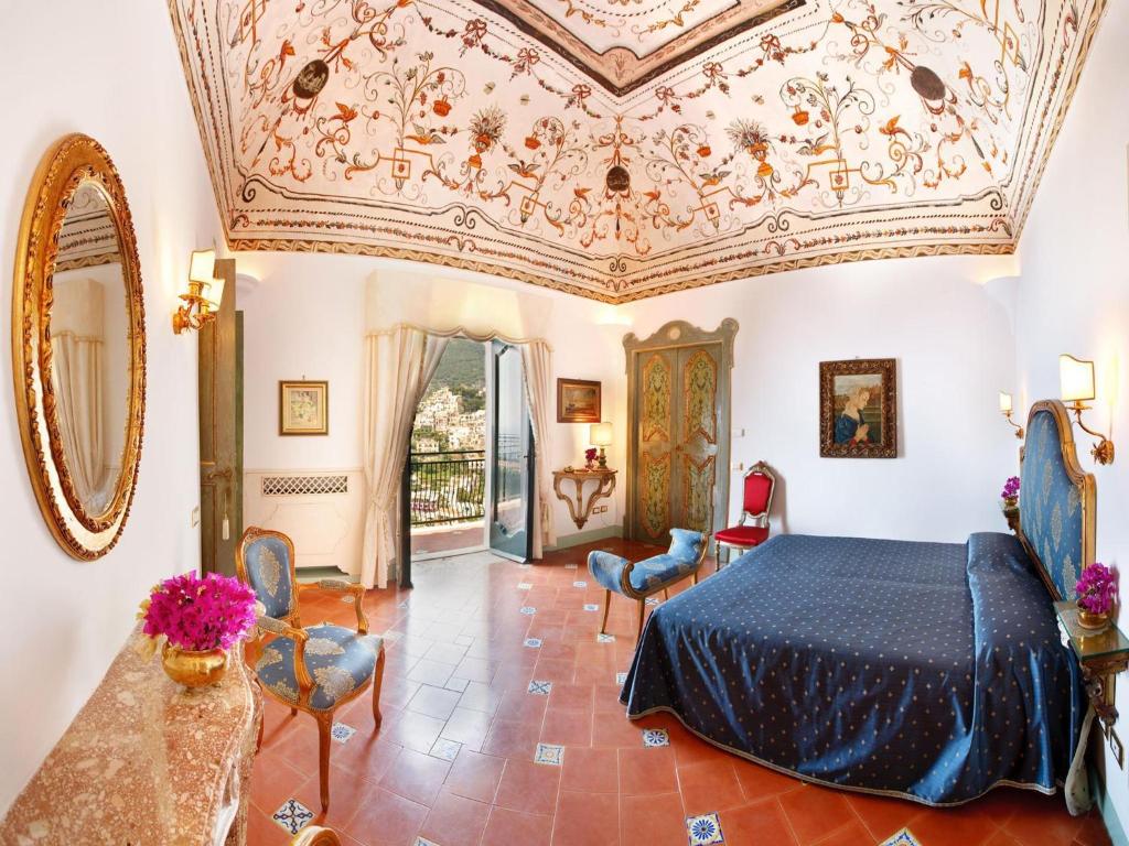 波西塔诺Villa dei Fisici Positano的一间卧室设有一张床和格子天花板