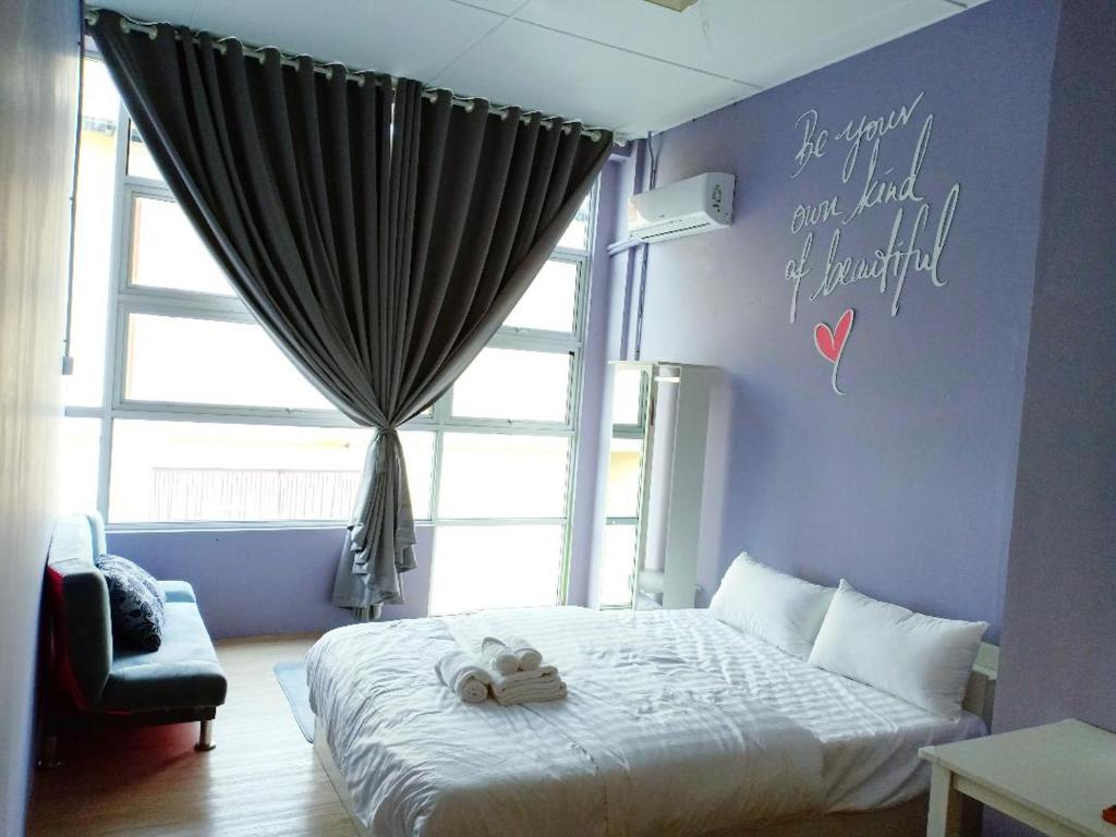 诗巫CJ Home的卧室配有一张挂有墙上标志的床