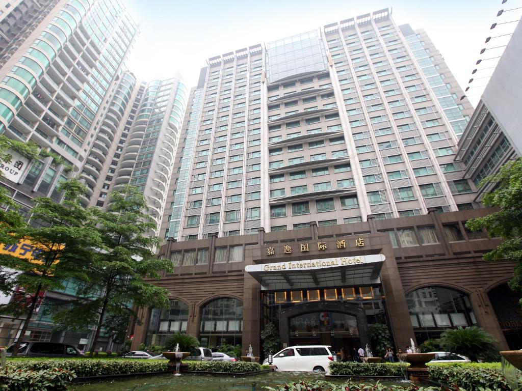广州嘉逸国际大酒店的前面有一辆白色汽车的高层建筑
