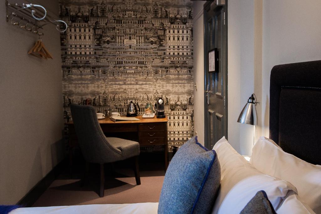 伦敦汉德鲜花酒店的酒店客房设有一张书桌,卧室配有一张床