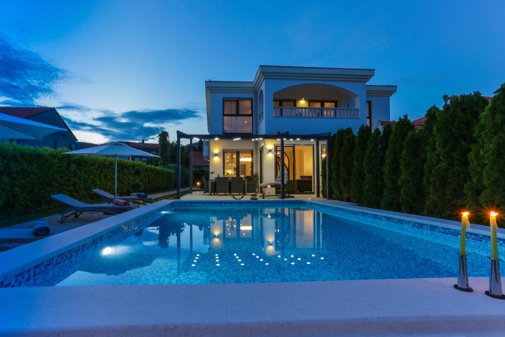 特罗吉尔Luxury City Villa Trogir的夜间带游泳池的别墅