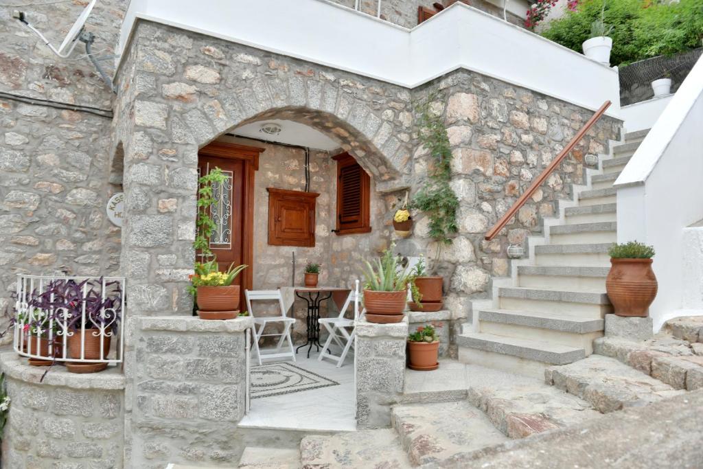 伊兹拉Kassandra House的石头房子,设有楼梯和桌椅