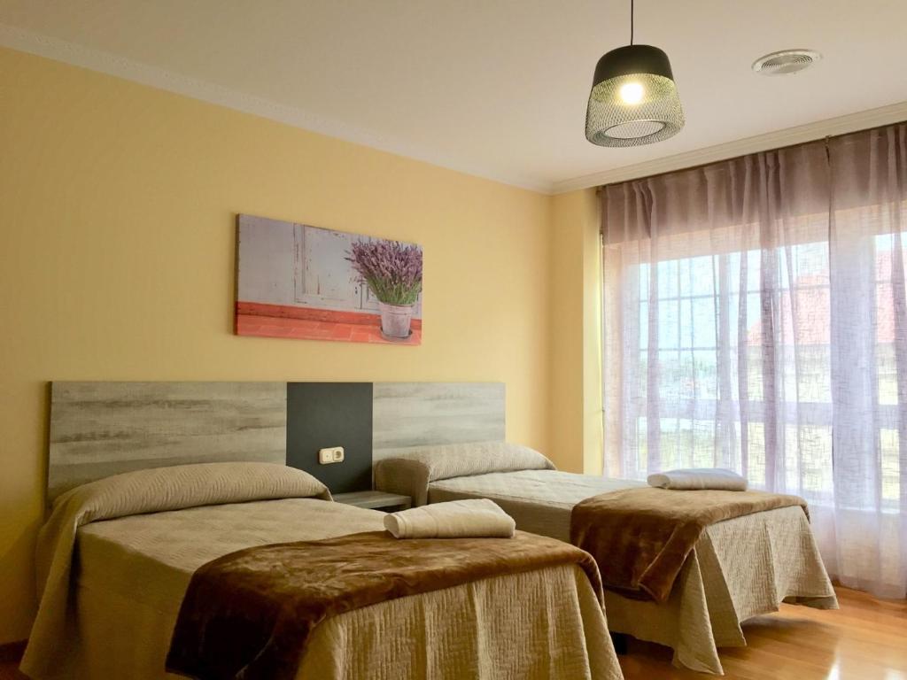 阿尔苏阿De Camino vivienda de uso turístico的一间设有两张床的客房,墙上挂着一幅画