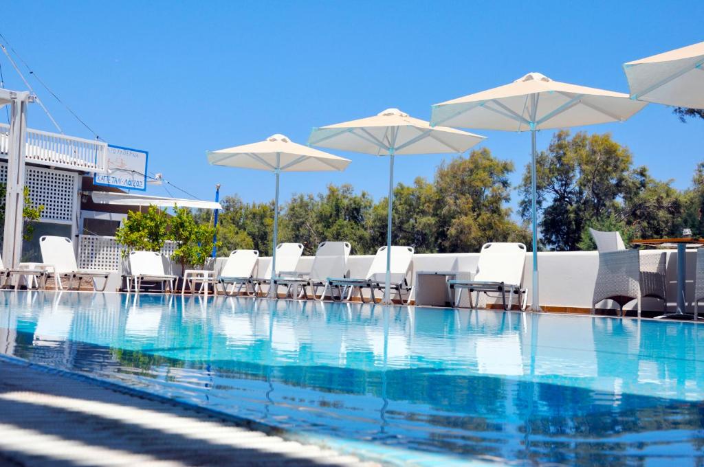 莫诺利索斯回忆海滩酒店 的一个带白色椅子和遮阳伞的游泳池